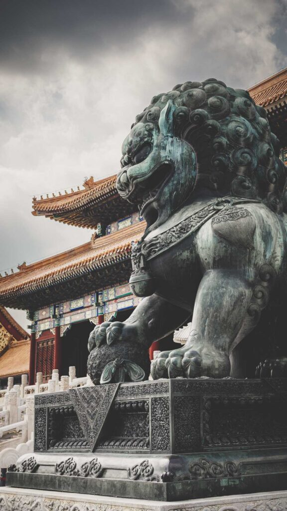 Bronze guardian lion statue outside a historic building in the Forbidden City in Beijing, China.