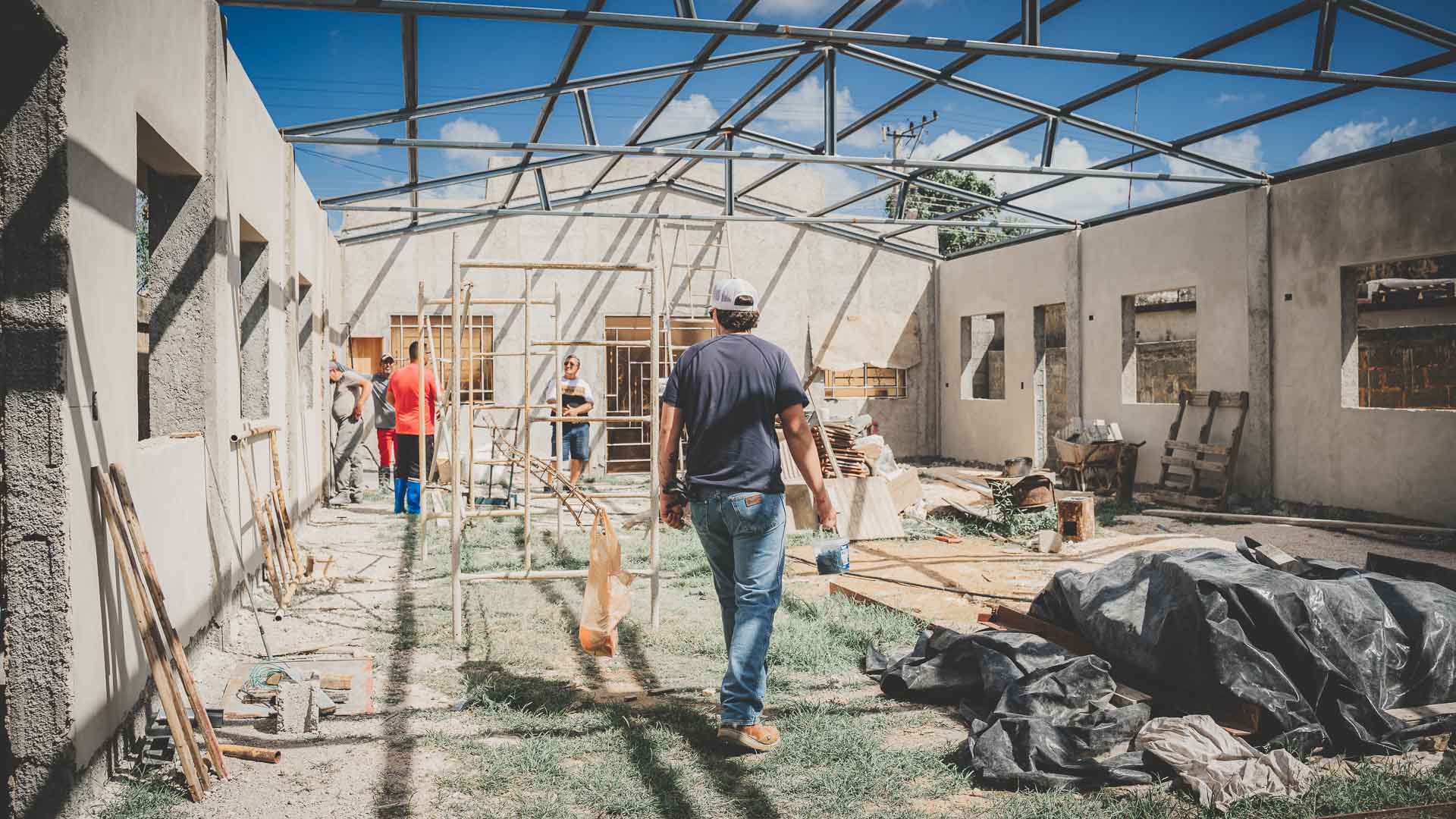 Church building under construction in Cuba with completed walls and steel roof framing.