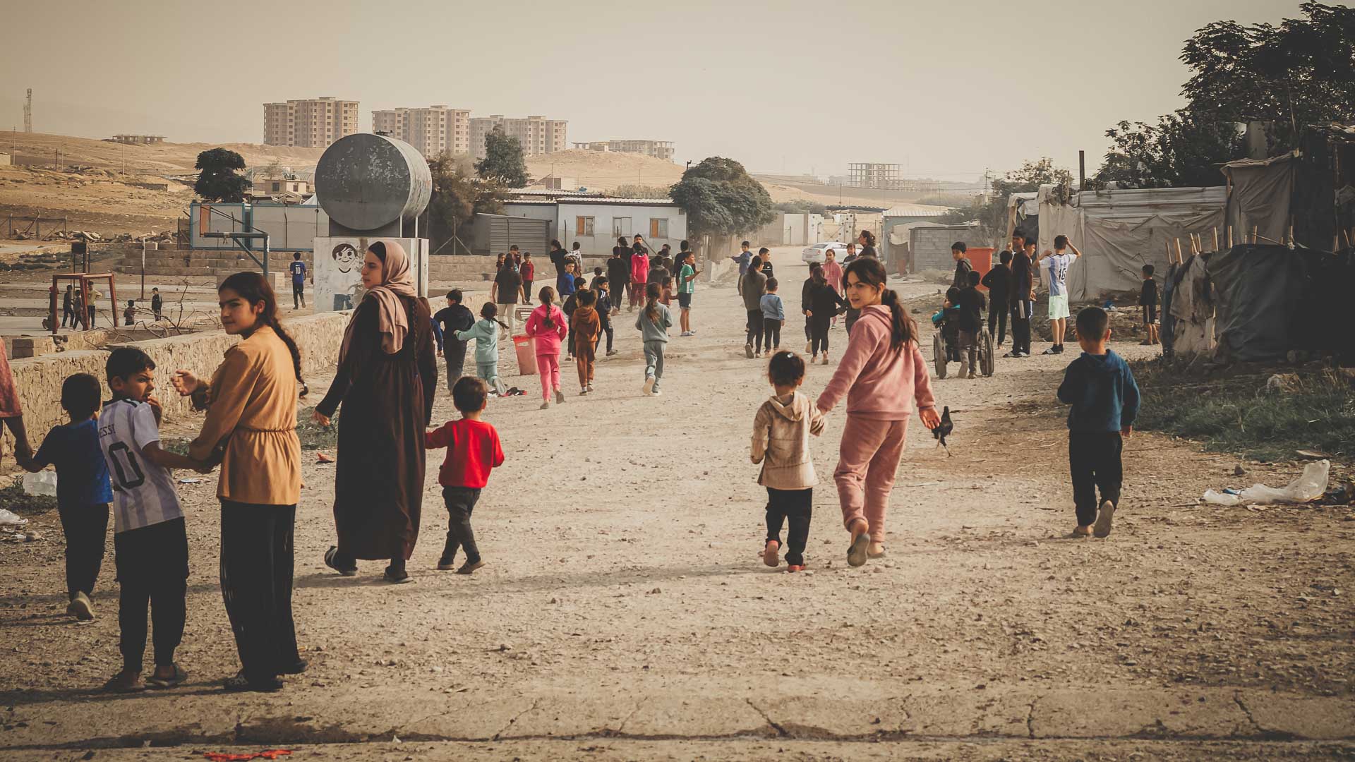 Families and children walking home after a community outreach event in Iraq.