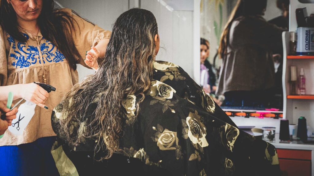 Woman participating in hair and beauty skills training for refugees in Iraq.
