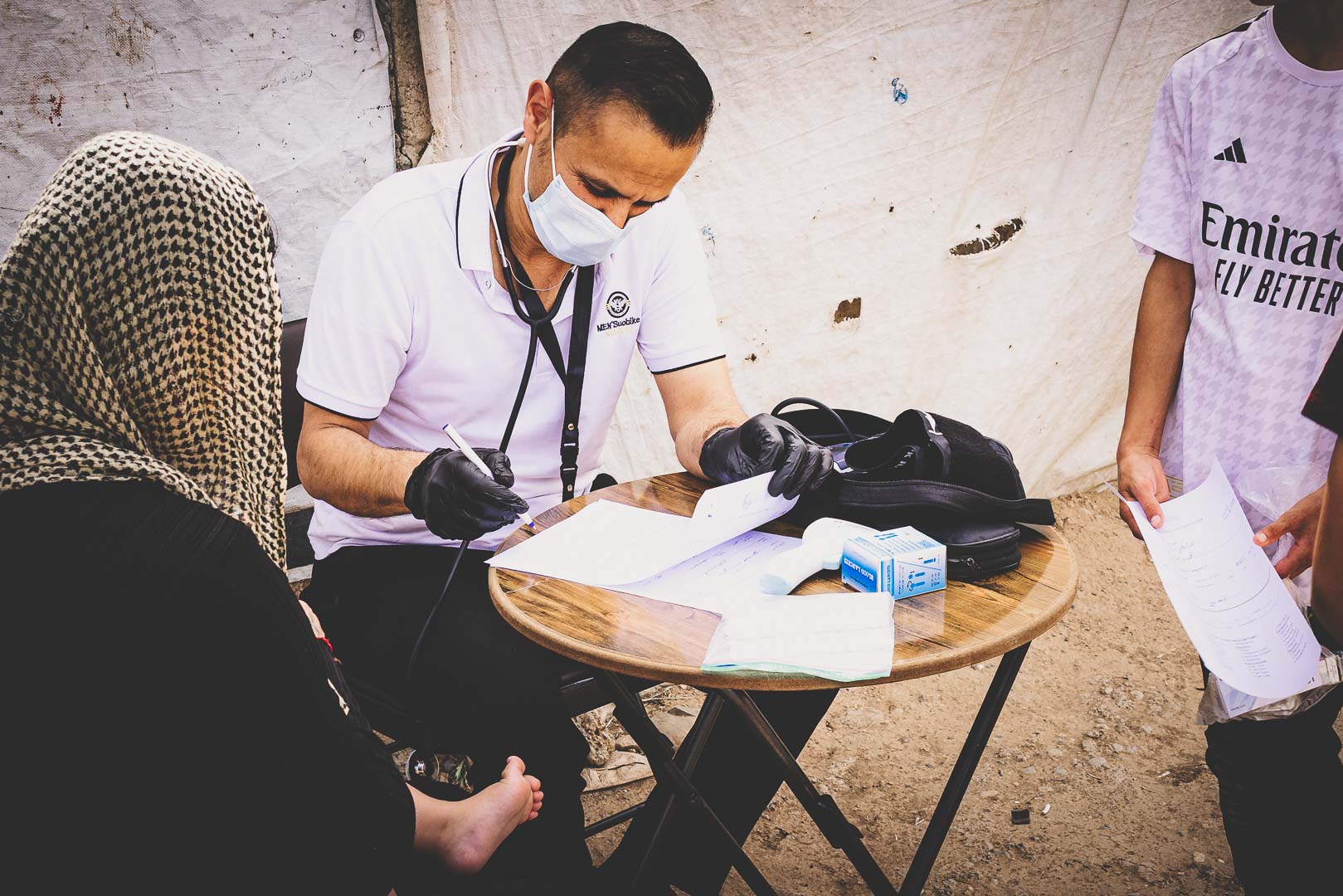 Medical worker caring for a patient during a mobile medical clinic in Iraq.