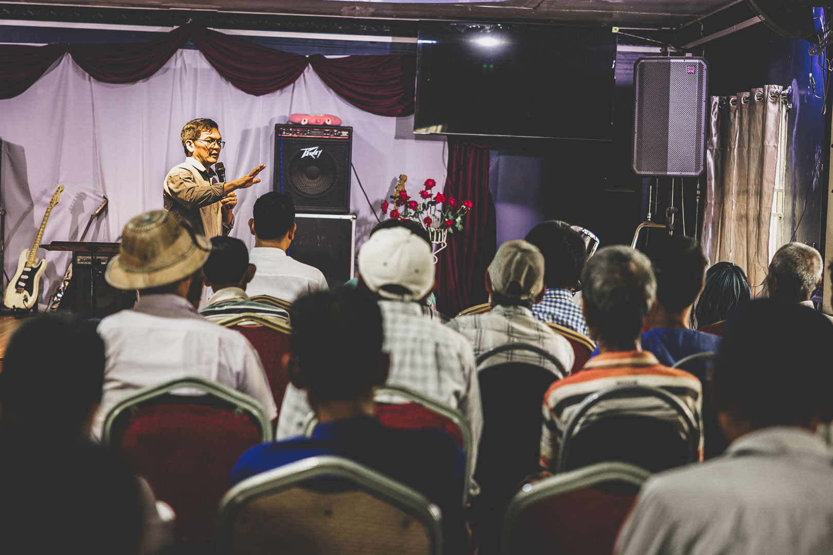 Local pastor speaking to people gathered for a church outreach event in Myanmar.