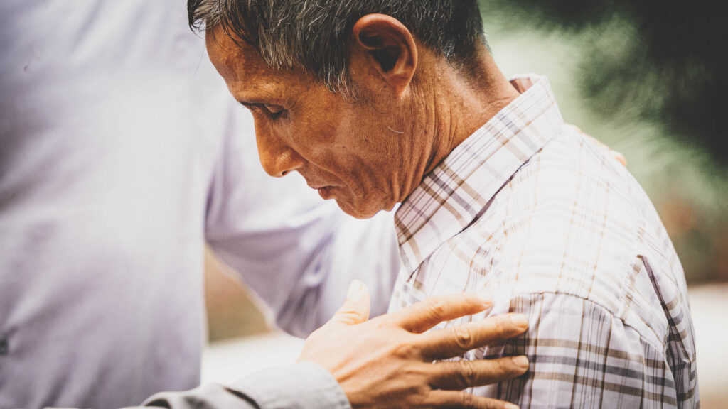 Ministry team praying for and encouraging a local pastor in Myanmar.