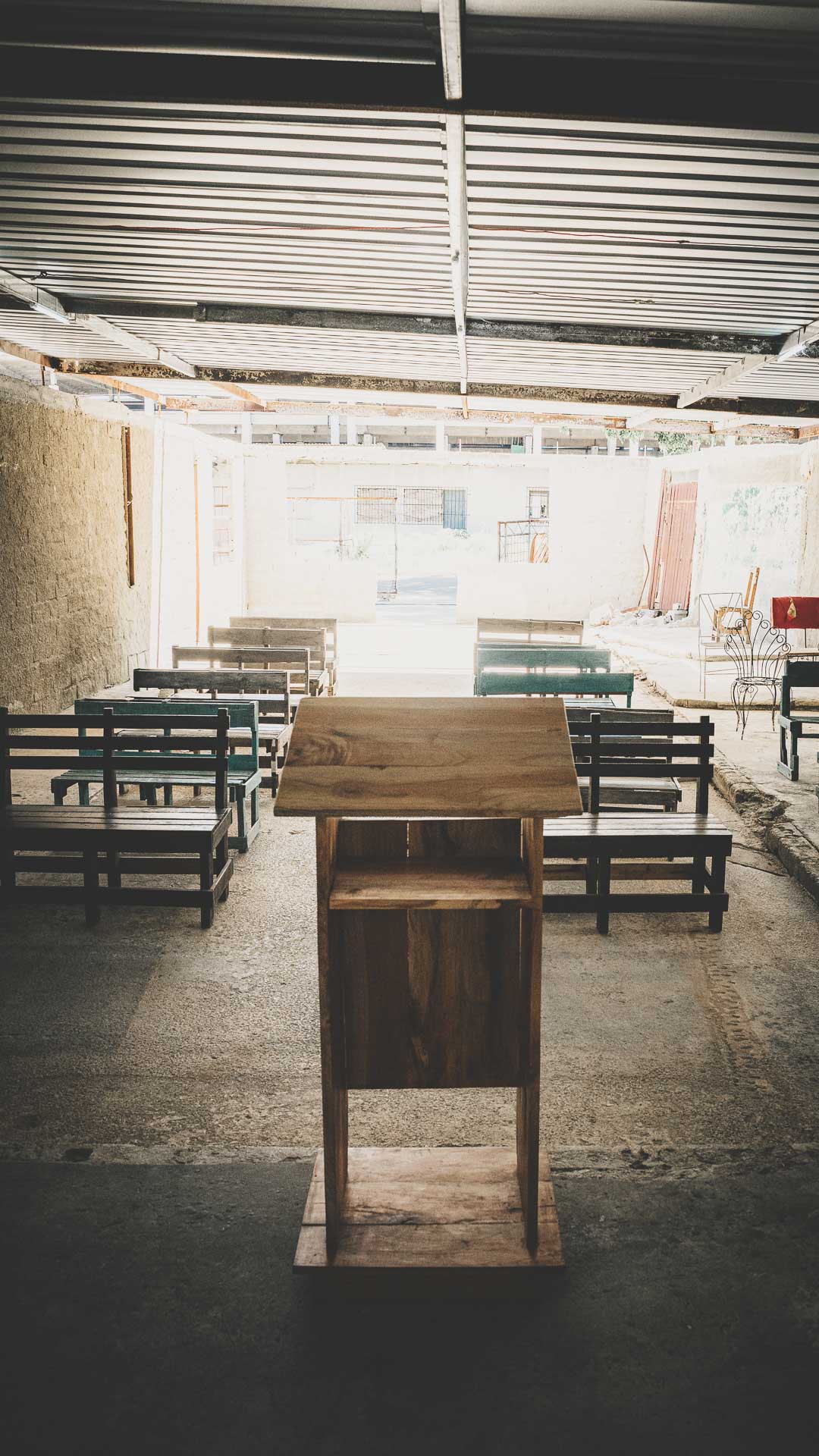 Simple local church interior with wooden pulpit, benches and corrugated roof in Havana, Cuba.
