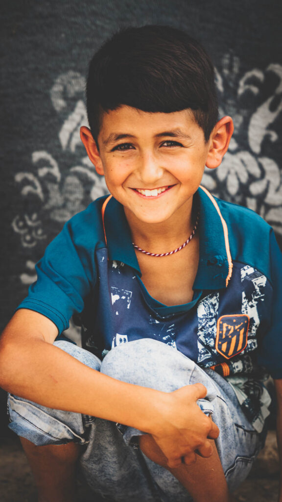 Young boy smiling for a portrait in Iraq.