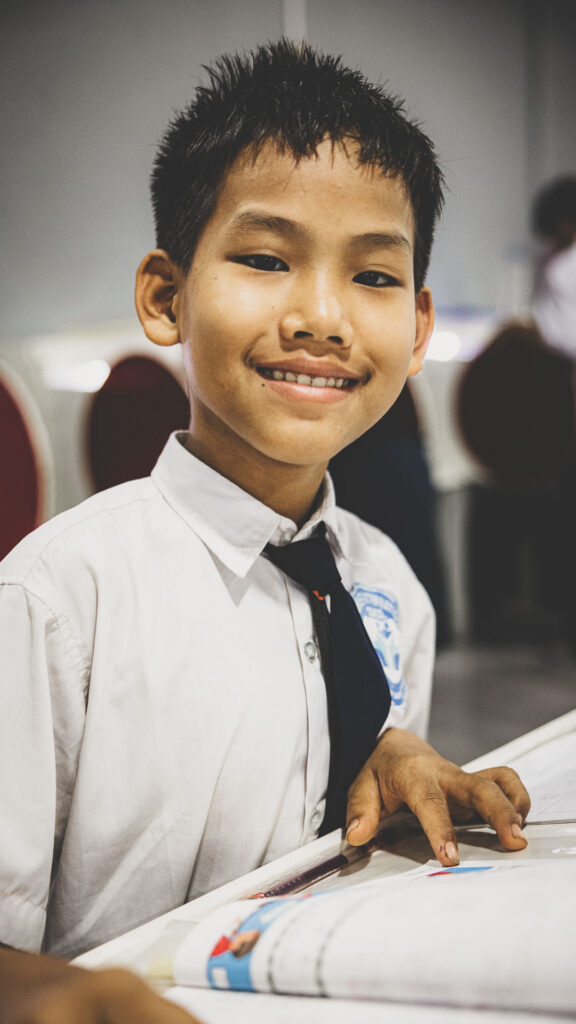 Student smiling while studying at Empower International School in Myanmar.