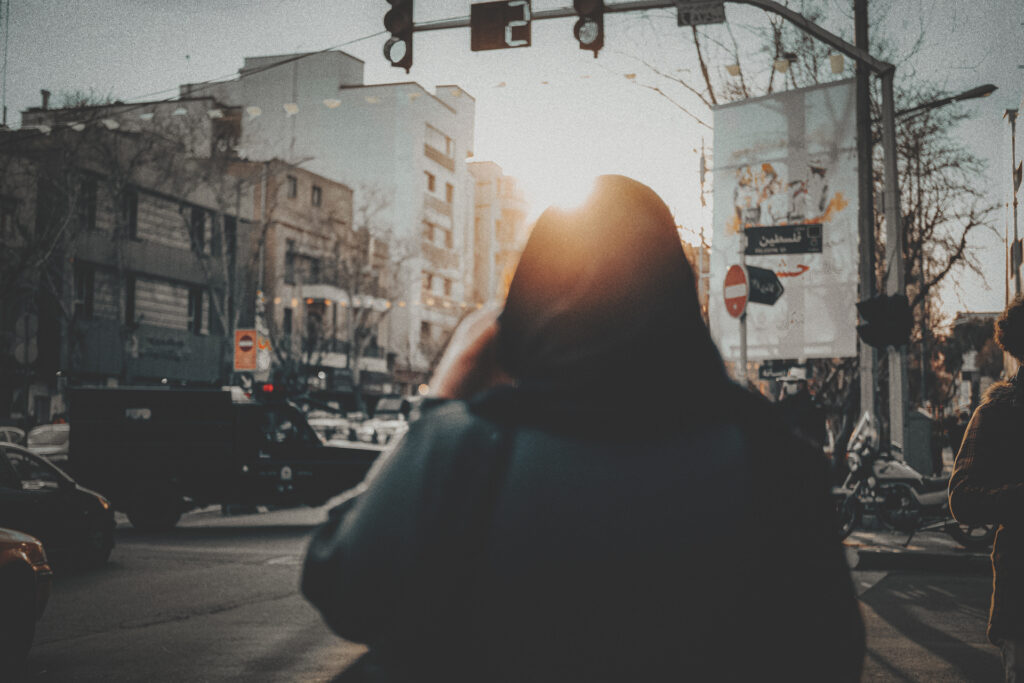 Pedestrian walking along an urban street in Iran.