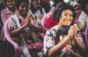 Children and adults seated together during a community gathering.