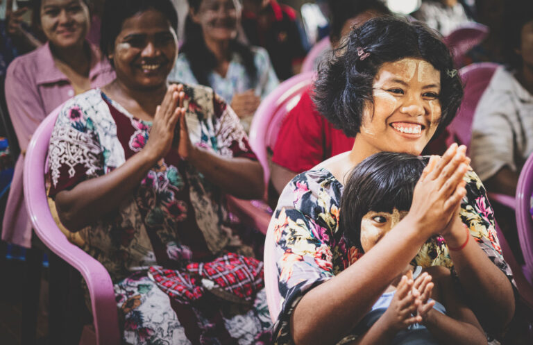 Children and adults seated together during a community gathering.